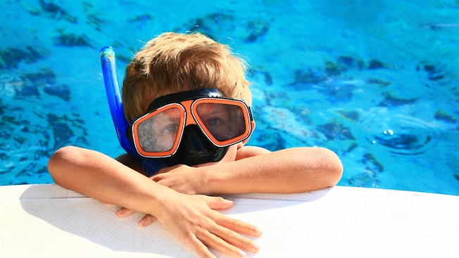 A young boy wearing a face plate and snorkel gear A young boy wearing a face plate and snorkel gear