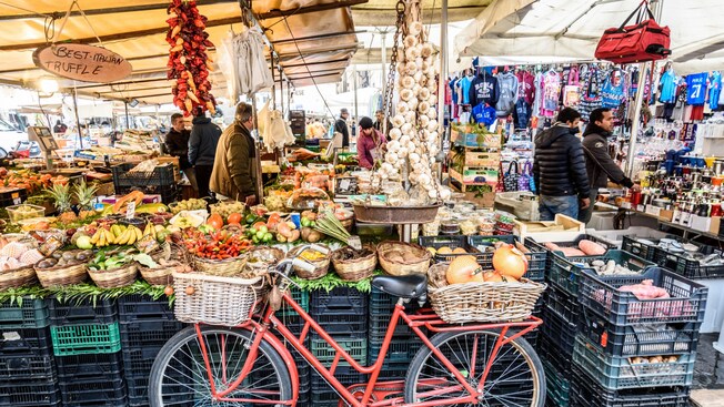 People buying fruits, vegetables and souvenirs at Campo de Fiori market in Rome