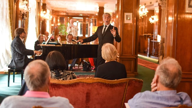A singer and a pianist performing in a lounge full of Guests A singer and a pianist performing in a lounge full of Guests