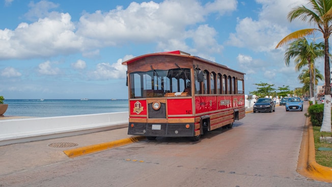 An old fashioned trolley car parked on an oceanfront street An old fashioned trolley car parked on an oceanfront street