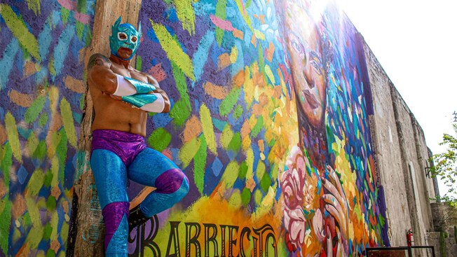 A wrestler in front of a building that reads, ‘Barriecito’ in Cozumel, Mexico