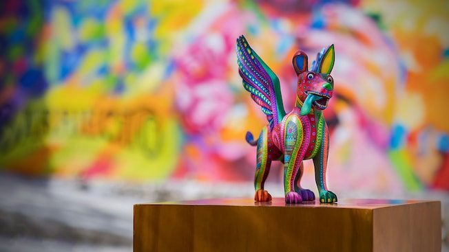 A painted wood carving of a mythical creature, mounted on a wood block A painted wood carving of a mythical creature, mounted on a wood block