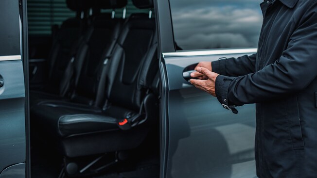 Motorista abrindo a porta de um SUV particular