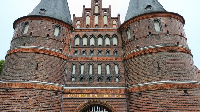 A medieval brick building with 2 brick towers