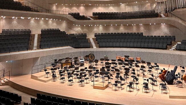 Inside the spacious Elbphilharmonie Concert Hall in Hamburg, with chairs and select instruments on stage