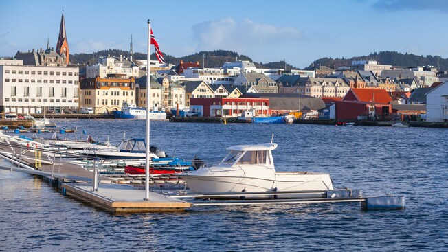 Boats on the water next to the Norwegian flag in Haugesund in Norway