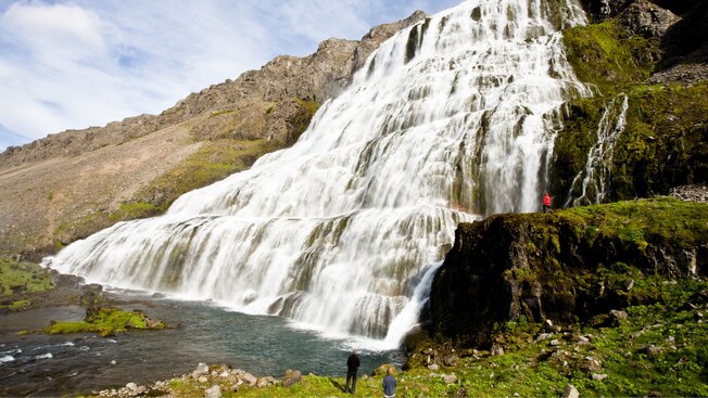 3 people standing near a multi level waterfall