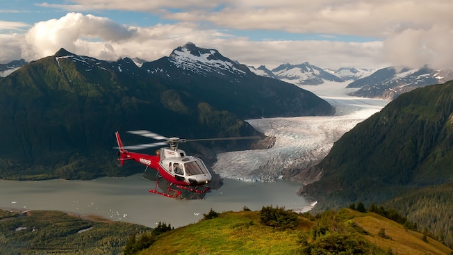 A helicopter flying in the sky near snow dusted mountains A helicopter flying in the sky near snow dusted mountains