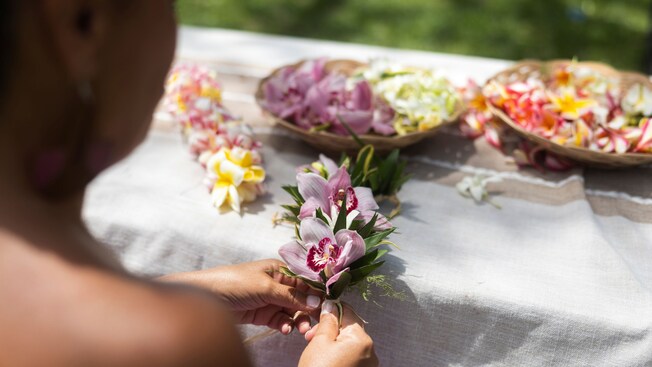 A woman making a haku lei