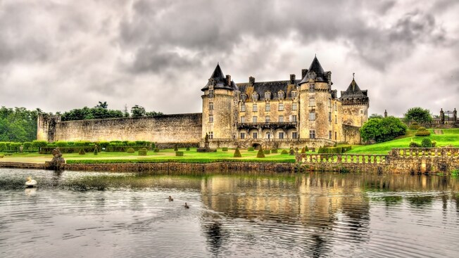 A castle with lush grounds overlooking the water