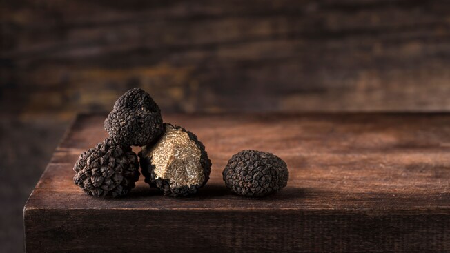 Four truffles piled on a wooden table