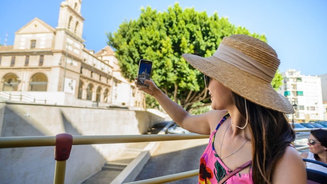 A Guest takes a picture on a mobile phone during a bus tour in Málaga, Spain A Guest takes a picture on a mobile phone during a bus tour in Málaga, Spain
