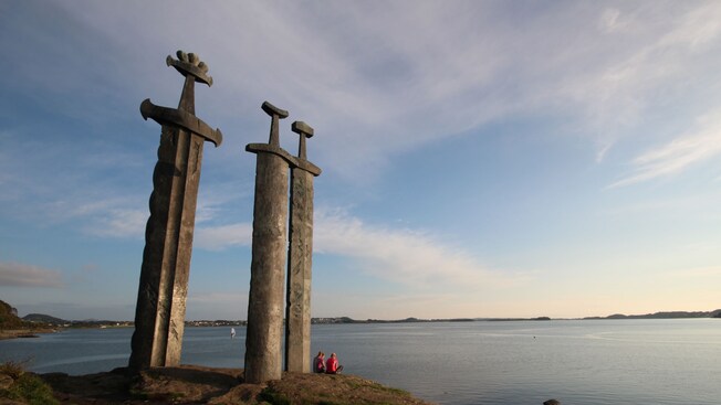 The Swords in the Rock monument in Stavanger dwarfs 2 women sitting on the ground