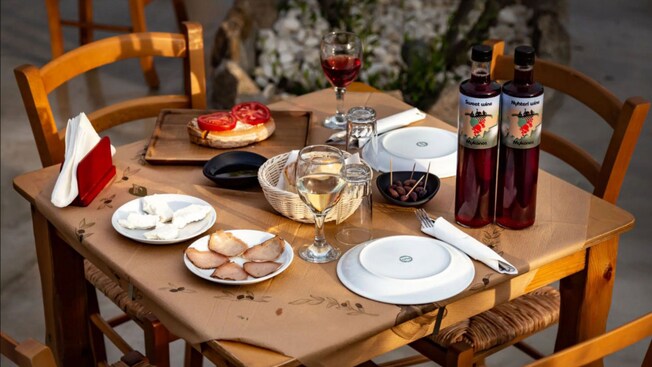 Una mesa con vino y aperitivos