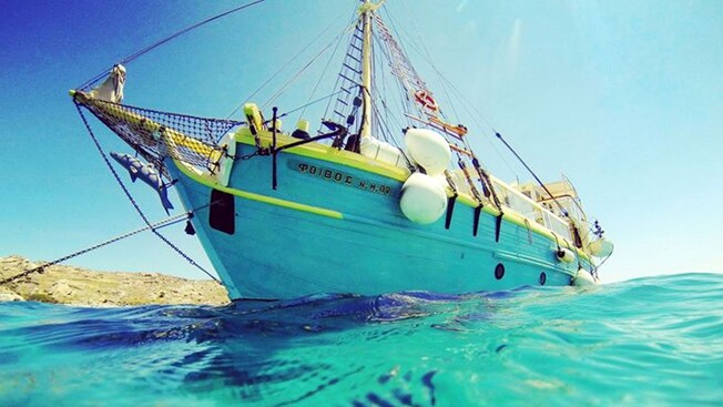 A traditional Aegean schooner sailing through the water