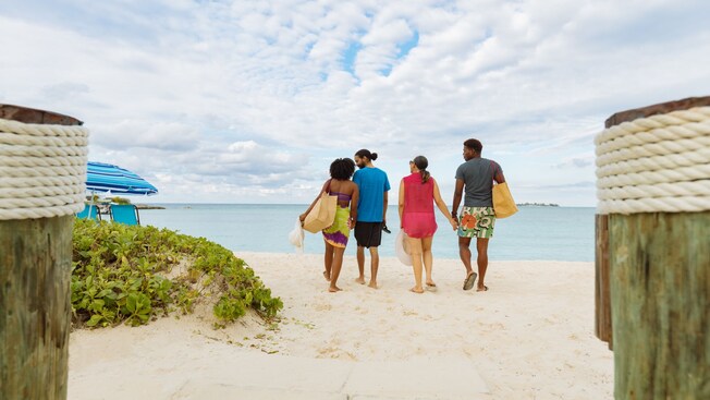 Two couples holding hands and walking towards the ocean in Nassau in The Bahamas