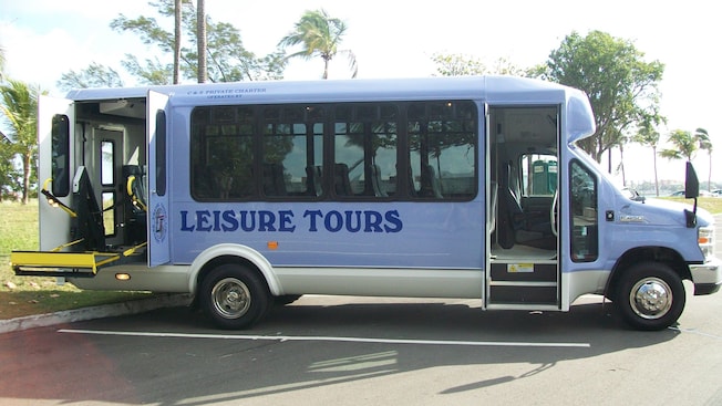 An accessible tour van with a vehicle lift and writing on the side that says ‘Leisure Tours’ An accessible tour van with a vehicle lift and writing on the side that says ‘Leisure Tours’
