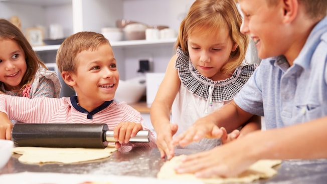 A group of kids making pizza A group of kids making pizza