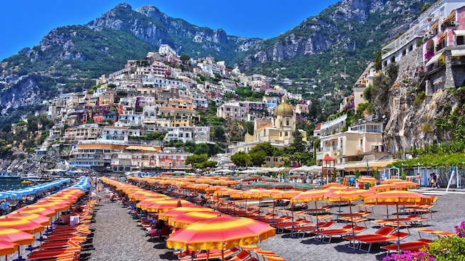 The coastal shores of Positano’s Spiaggia beach with umbrellas and chairs The coastal shores of Positano’s Spiaggia beach with umbrellas and chairs