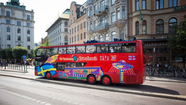 Un autobús turístico de dos pisos con las palabras “City Sightseeing Scandinavia” y “Hop On Hop Off”