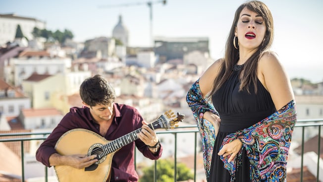 A woman singing with a man playing a Portuguese guitar during a Fado performance in Porto A woman singing with a man playing a Portuguese guitar during a Fado performance in Porto