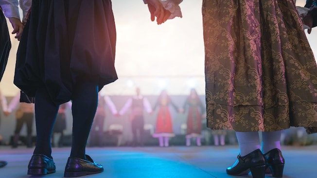 A group of dancers in a circle holding hands A group of dancers in a circle holding hands