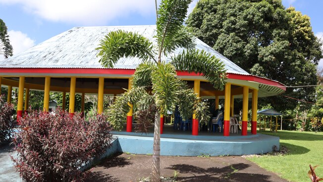 A pavilion in a lush, tropical landscape