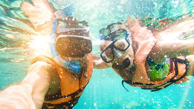 Two people wearing snorkeling gear underwater Two people wearing snorkeling gear underwater