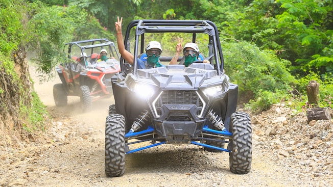 Two UTVs driving on a dirt road Two UTVs driving on a dirt road