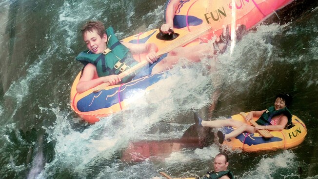 Un anuncio de cuatro&nbsp;personas realizando descenso por el río en tubos inflables que dice “Dominica River Tubing”