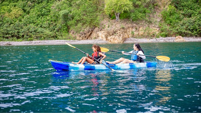 Two people paddling in a kayak along the Waitukubuli Sea Trail in Roseau, Dominica