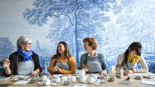 4 women laughing and smiling while painting pottery 4 women laughing and smiling while painting pottery