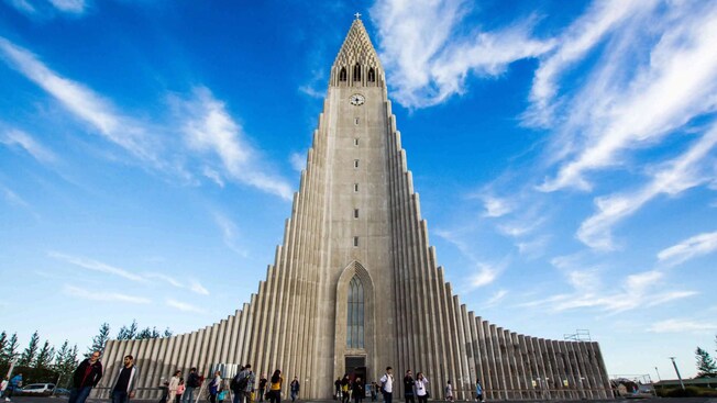 Uma grande torre de igreja com alas feitas de colunas estreitas que se inclinam para encontrá-la