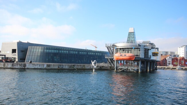 A large glass and steel building by the water