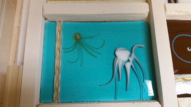 A piece of glass art depicting jellyfish