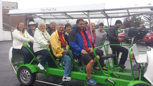 A tour group sitting in a 15-seat passenger bicycle