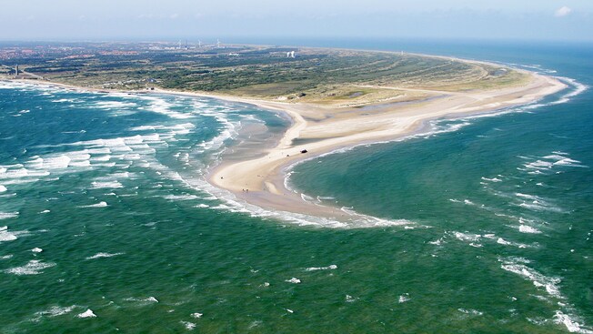 A landmass with a peninsula stretching out into a choppy body of water