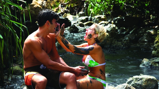 A man and a woman playfully smearing each other with mud A man and a woman playfully smearing each other with mud