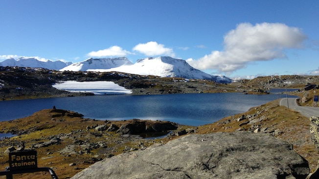 Un cuerpo de agua rodeado de rocas y montañas nevadas Un cuerpo de agua rodeado de rocas y montañas nevadas