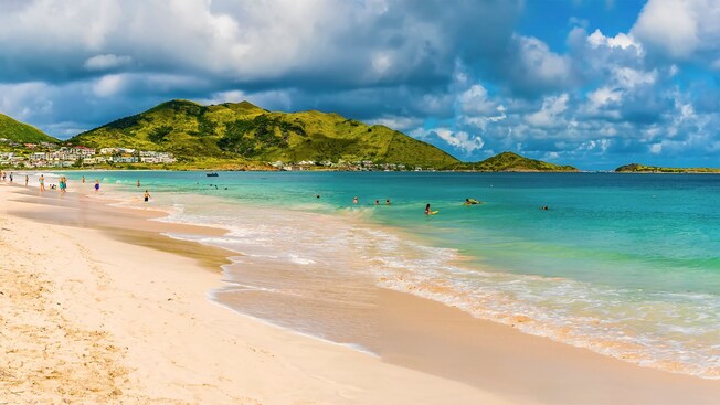The shoreline of Orient Bay Beach on Saint Maarten with mountains in the background
