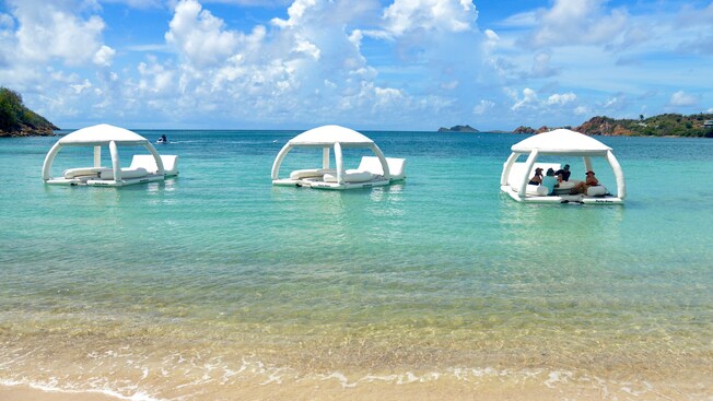 3 floating cabanas in the waters of a tropical beach