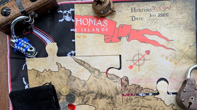 A completed puzzle of a treasure map with golden doubloons on top