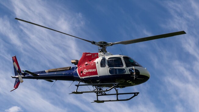 A Helitrans Airbus helicopter flying in the sky