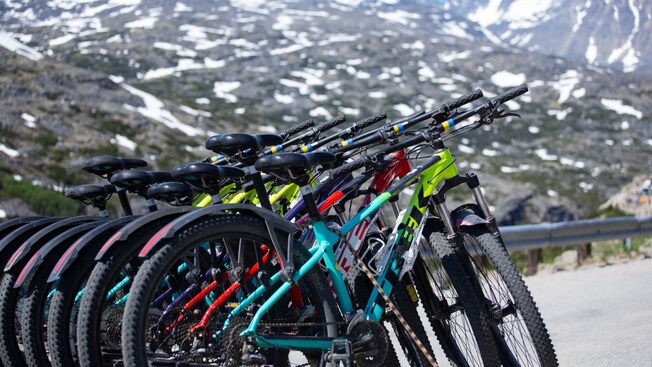 A group of bicycles parked in a row near a mountain in Skagway, Alaska