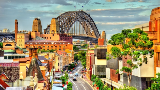 Historic and modern buildings flanking a city street with the Sydney Harbour Bridge Historic and modern buildings flanking a city street with the Sydney Harbour Bridge