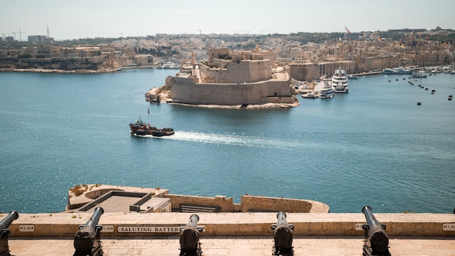Cannons overlooking Grand Harbor in Valletta and the city in the background Cannons overlooking Grand Harbor in Valletta and the city in the background