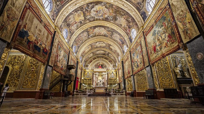 A Nave da Catedral de São João, com paredes e teto cobertos por pinturas e tapeçarias ornamentadas