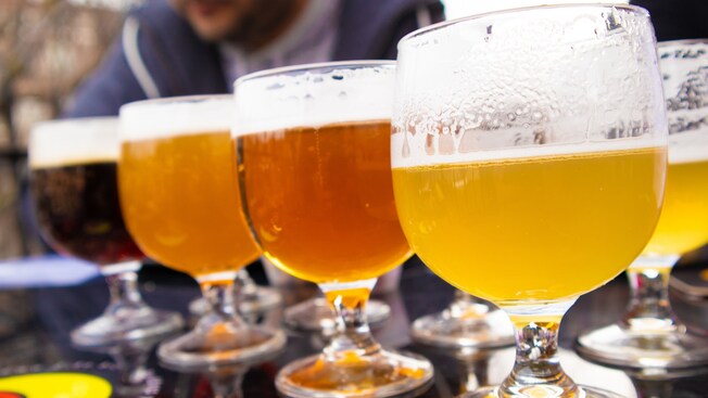 A flight of 4 different beers and tasting glasses on a table