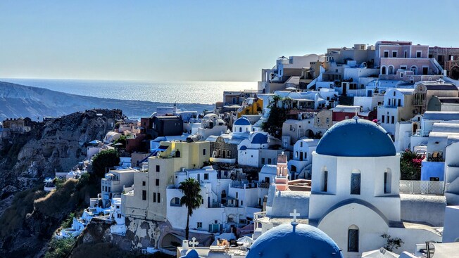 Mediterranean style buildings with domed roofs on a hillside overlooking the sea