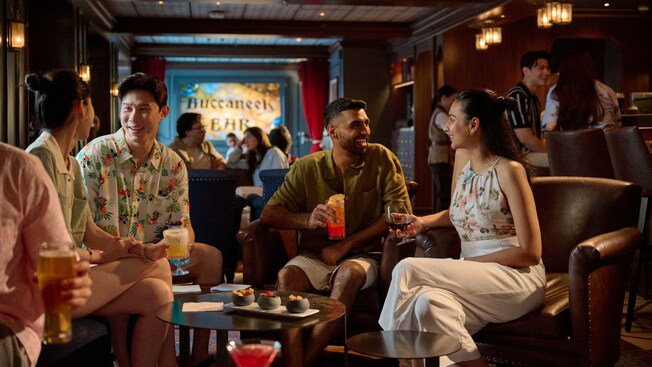 Guests enjoying cocktails inside of Buccaneer Bar aboard the Disney Adventure cruise ship